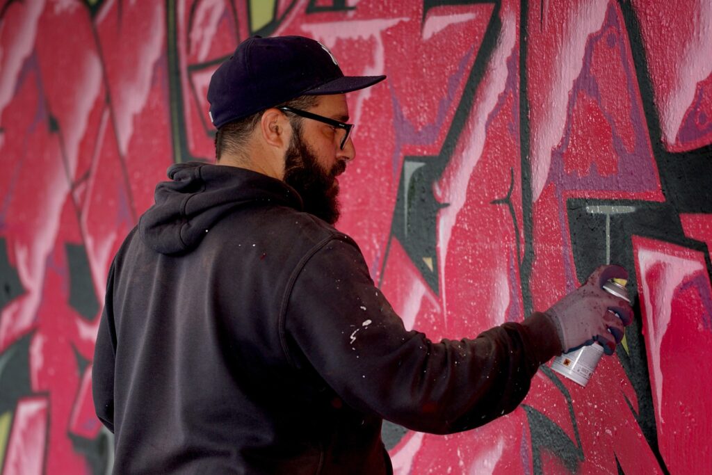 Nox Keller Artist, ist am sprayen, ein rotes Graffiti