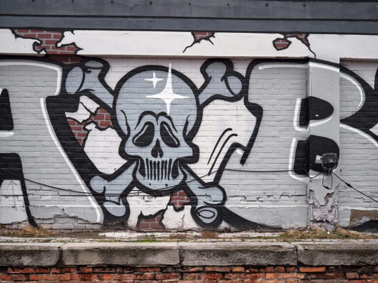 graues graffiti mit einem Totenkopf auf einer beton wand