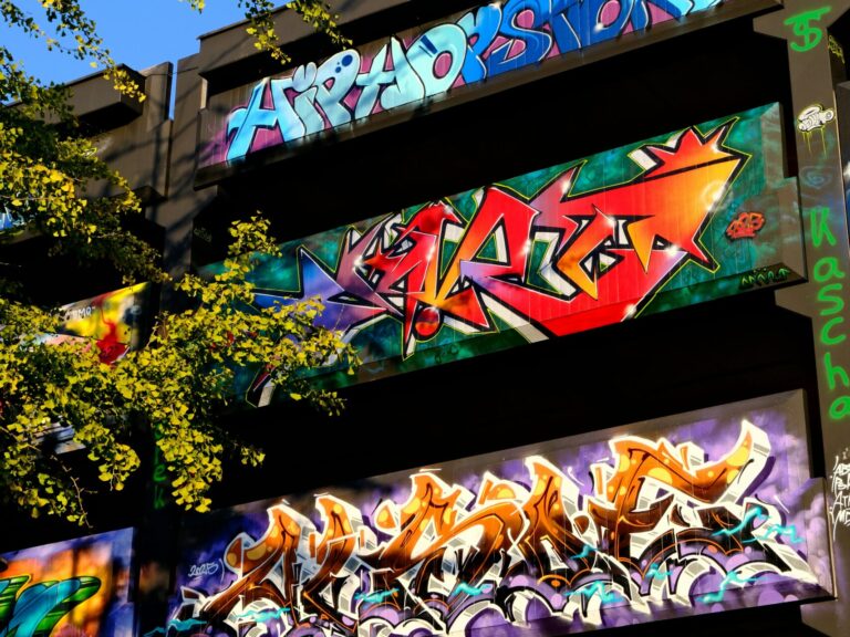 buntes graffiti an einer parkaus wand, bäume im vordergrund