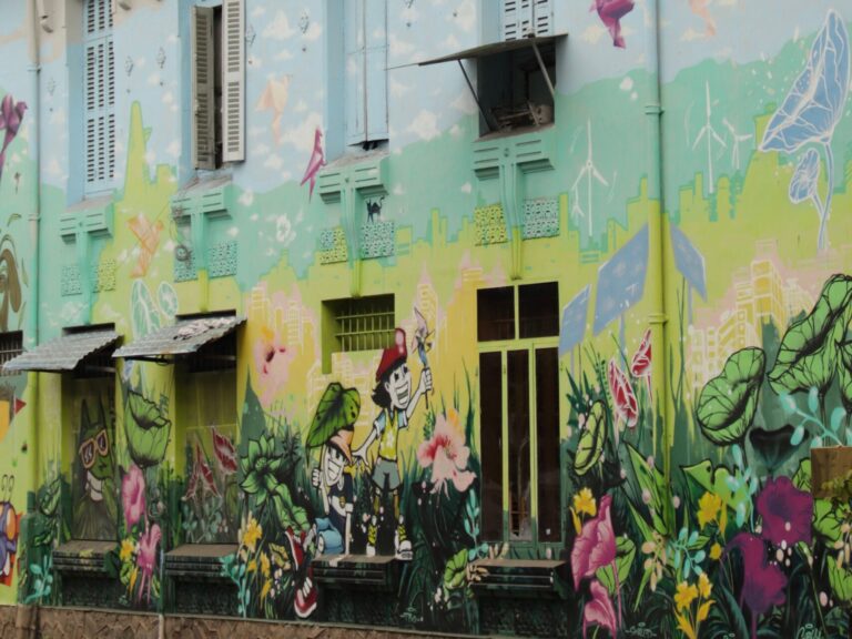 Pastelfarbenes Graffiti auf einer gelben Hauswand. Natürliche Formen und Tiere