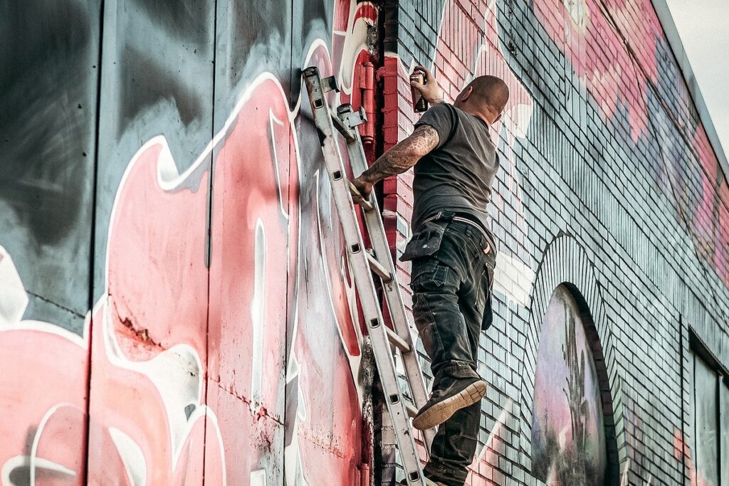Man malt ein rotes Graffiti an die Wand